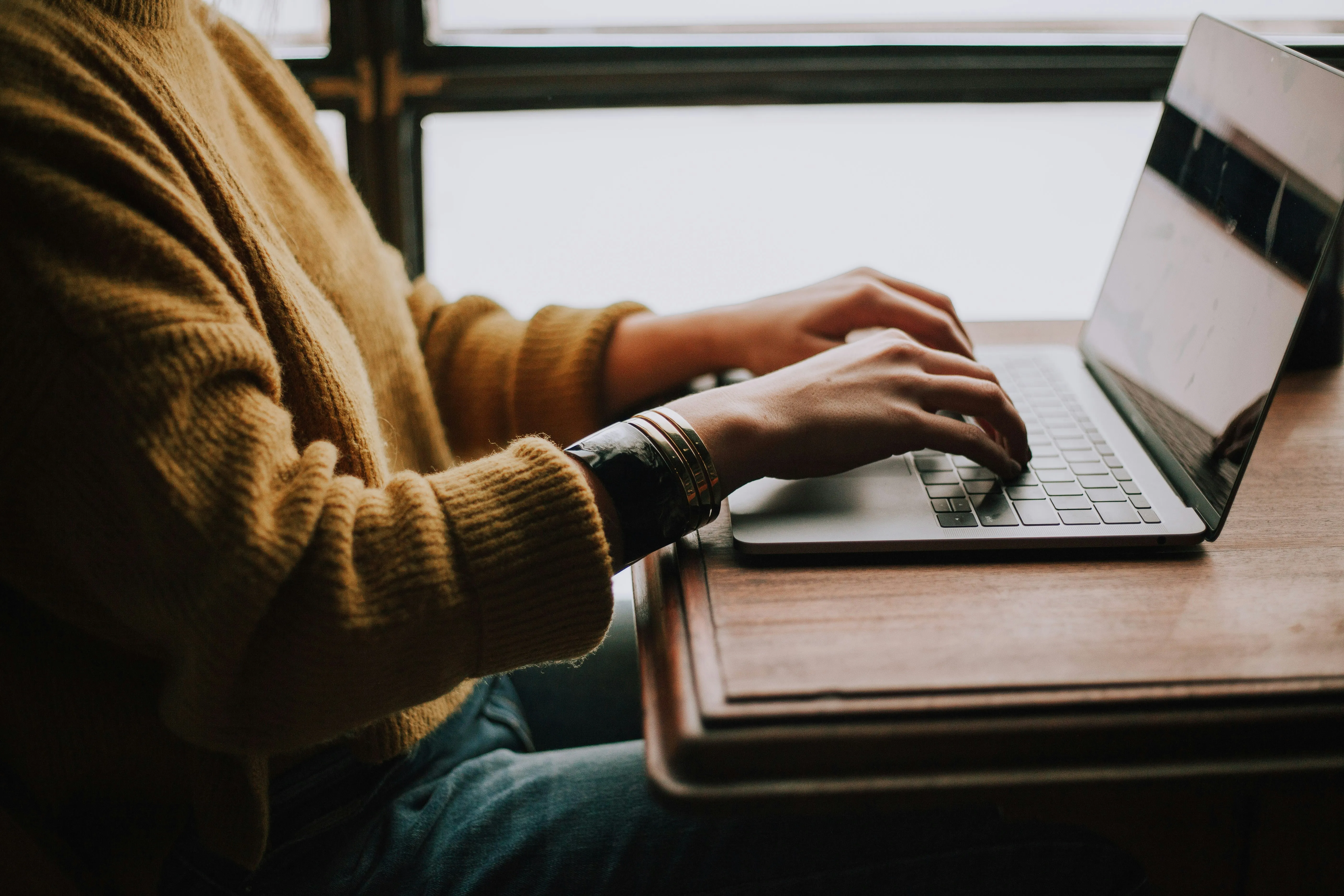 A person working on a laptop at a desk.